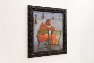 Girl in a red dress reading by a swimming pool