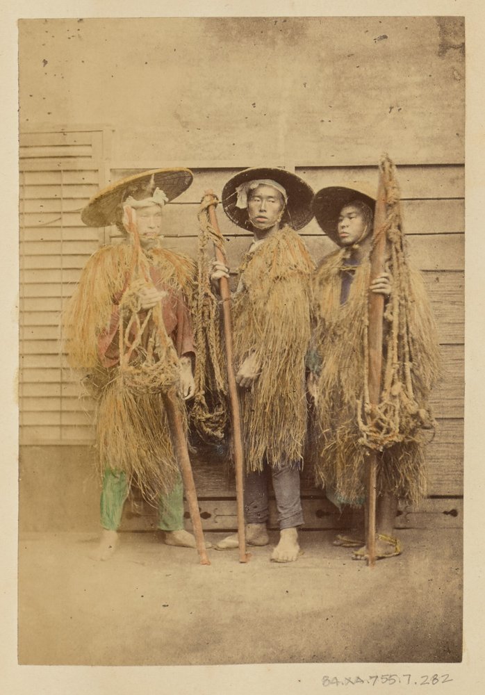 Three Japanese Men in Grass Robes and Wide-Brimmed Hats