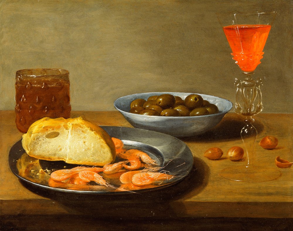A plate with prawns and a roll and bowl with olives