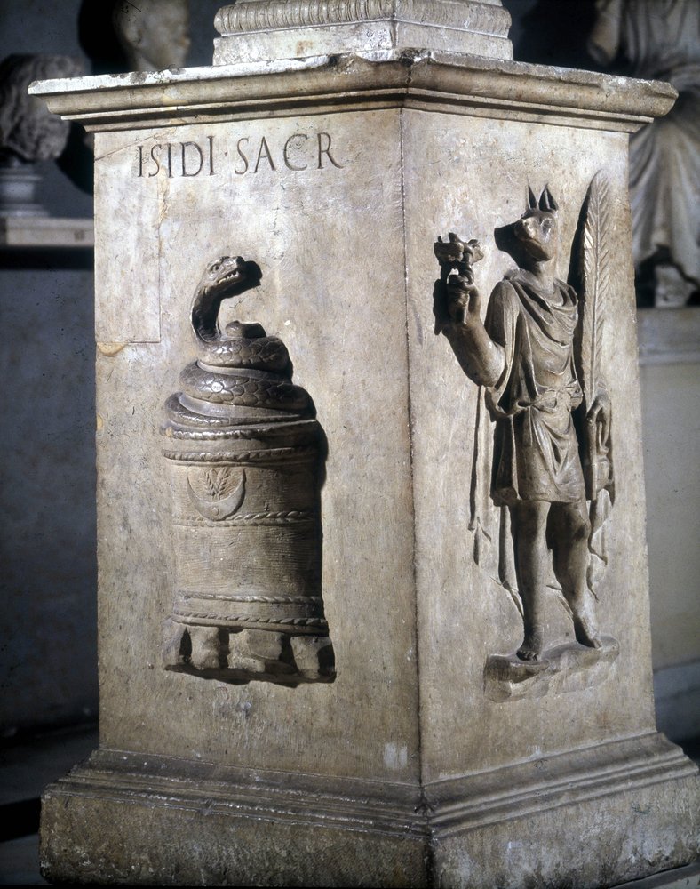 Altar dedicated to Isis. Left: mystic stone with snake and right: Anubis-Hermès. The words 