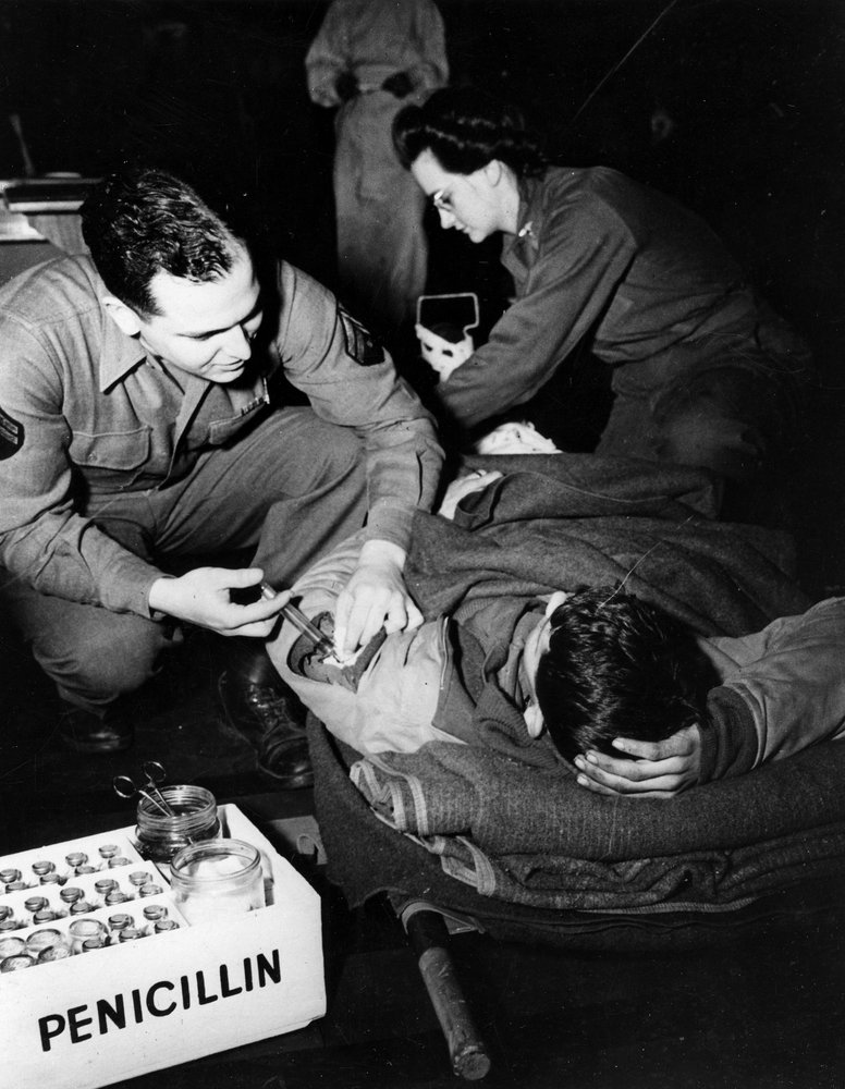 Second World War (1939-1945) - World War II (WWII or WW2): Luxembourg, February 1945: In a US Army evacuation hospital, a medic administers penicillin to an injured soldier to prevent infection while a nurse prepares him for an operation by Unbekannt