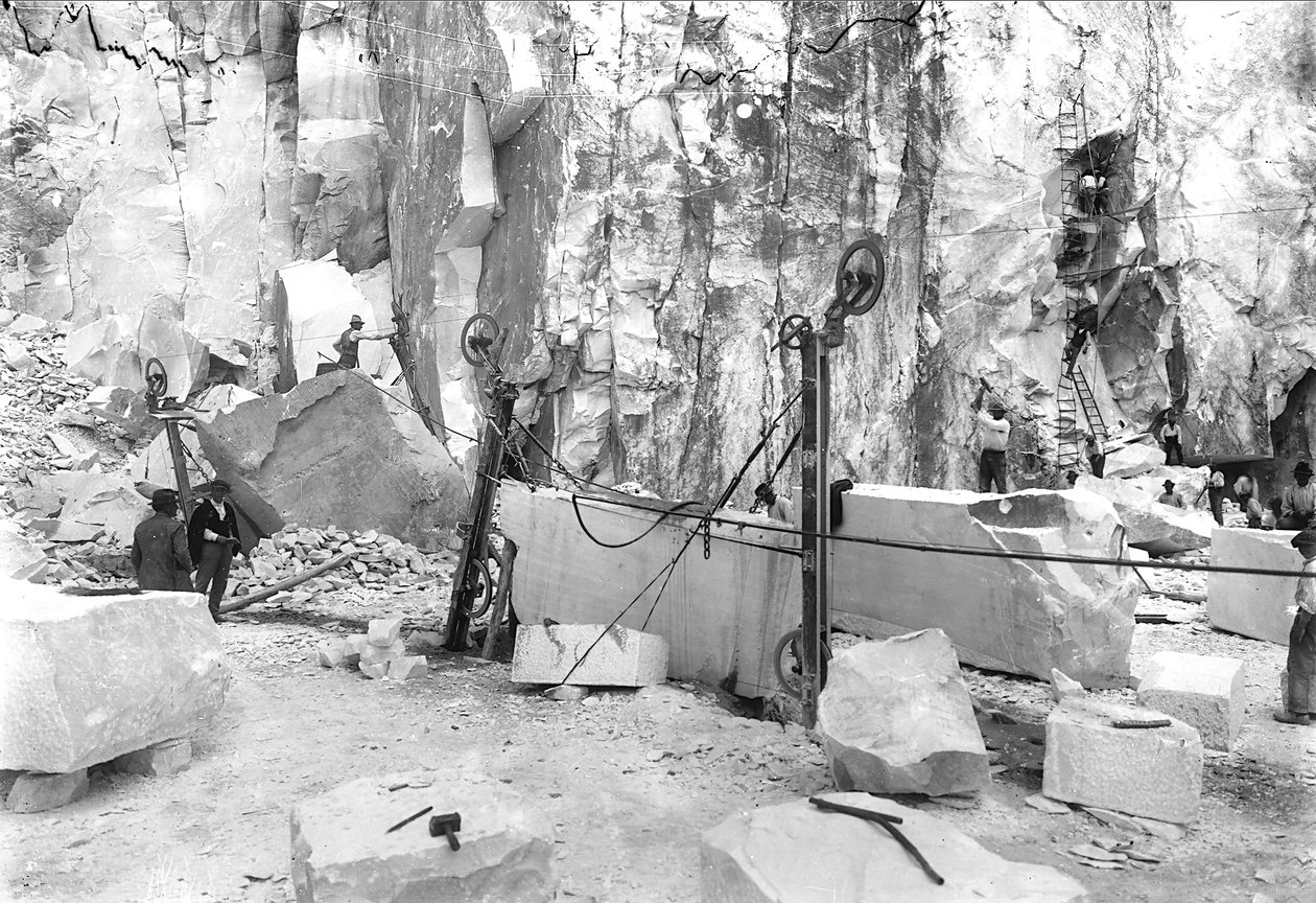 Excavators at work at a marble quarry in the Apuan Alps, Tuscany. In the foreground there are blocks of marble already squared off. by A. Corsini