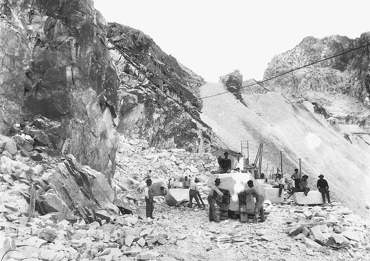 Excavators at work at a marble quarry in the Apuan Alps, Tuscany. Some of them are seated on blocks of marble already squared off. by A. Corsini