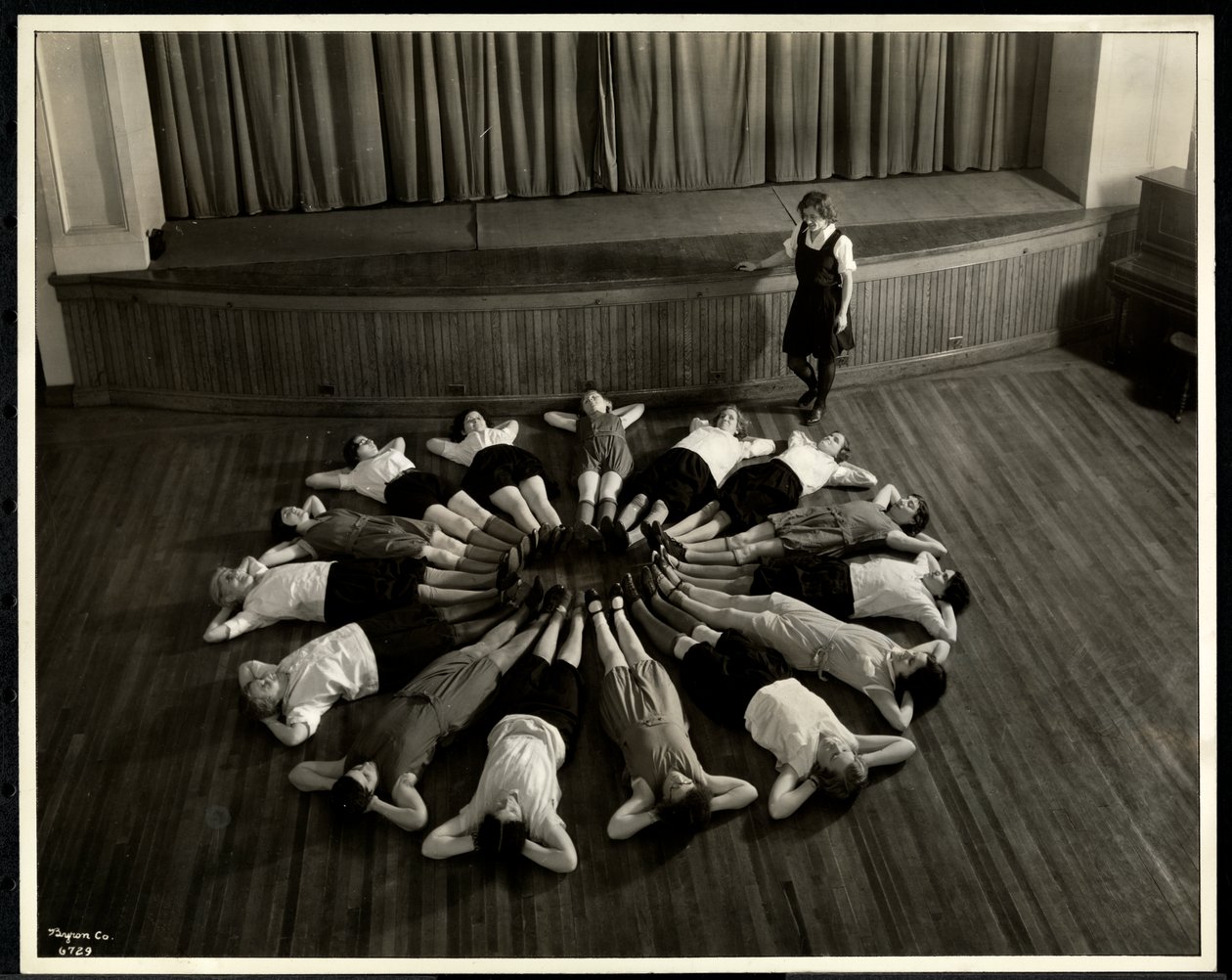 Young blind women lying in a starburst pattern on the floor of the gymnasium at the New York Association for the Blind, 111 East 59th Street, New York, 1933 by Byron Company