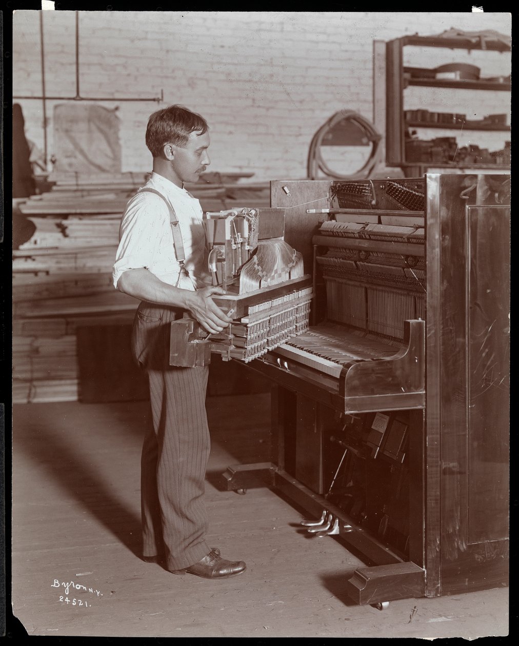 Man working in the Hardman, Peck und Co. piano factory, New York, 1907 by Byron Company