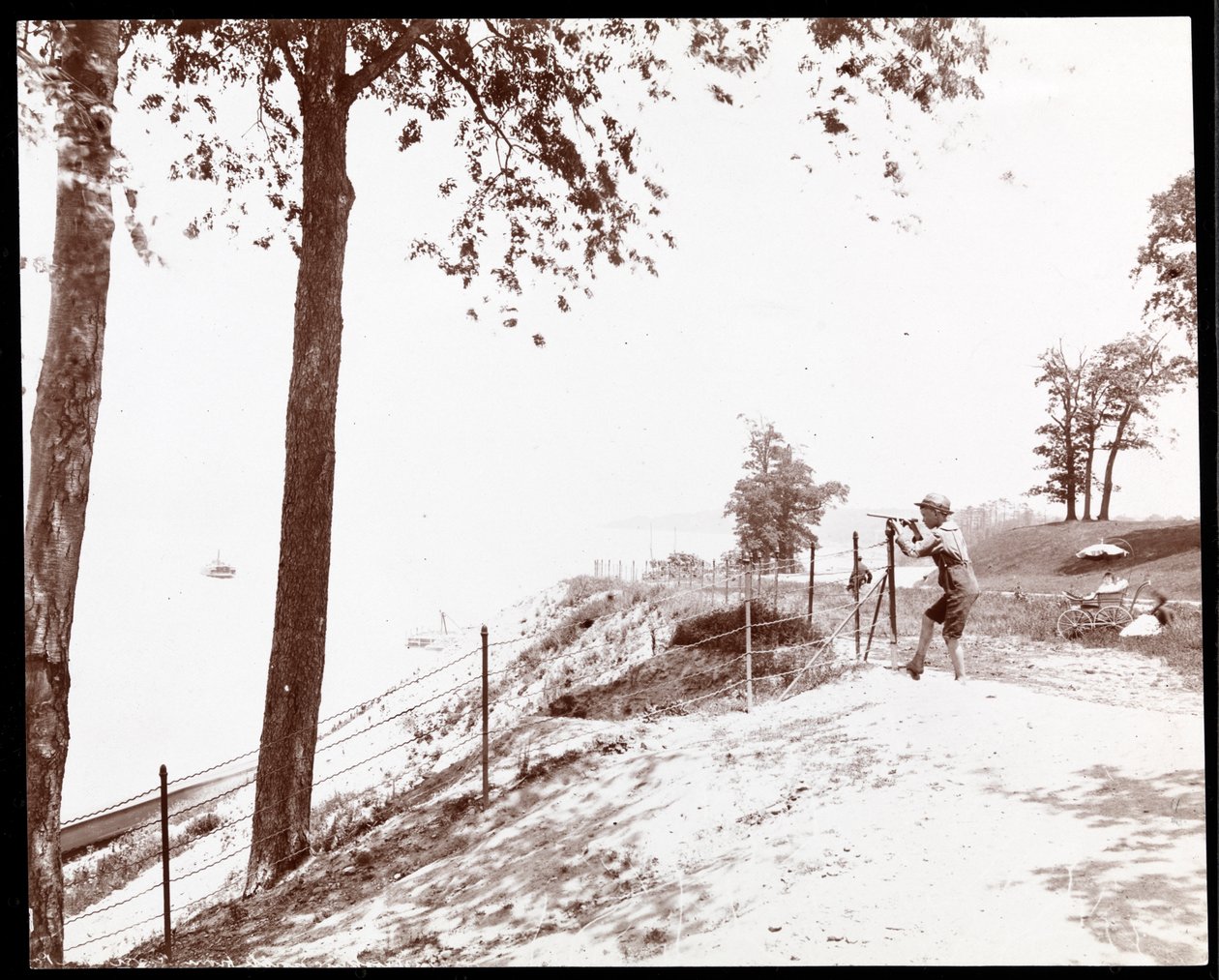 View of a Boy with a Spyglass Looking Toward the Hudson River from Riverside Park, New York by Byron Company