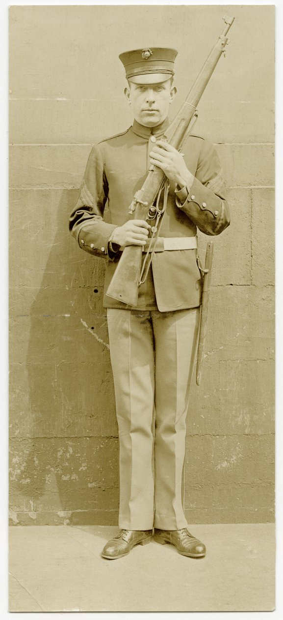 Uniformed Soldier Posing for a Picture in Front of a Concrete Wall by Carl Michel