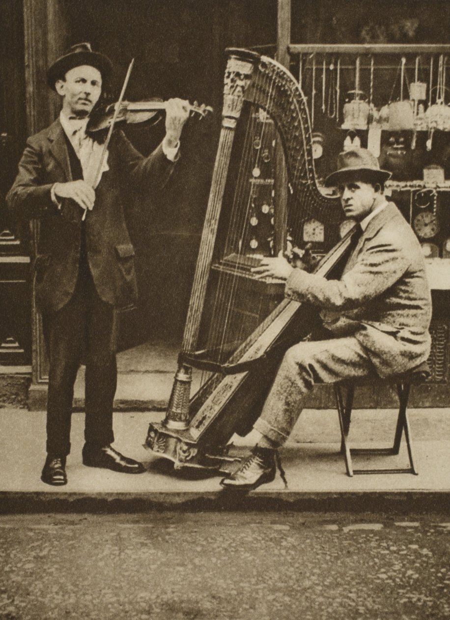 Street musicians: a harpist and violinist by English Photographer