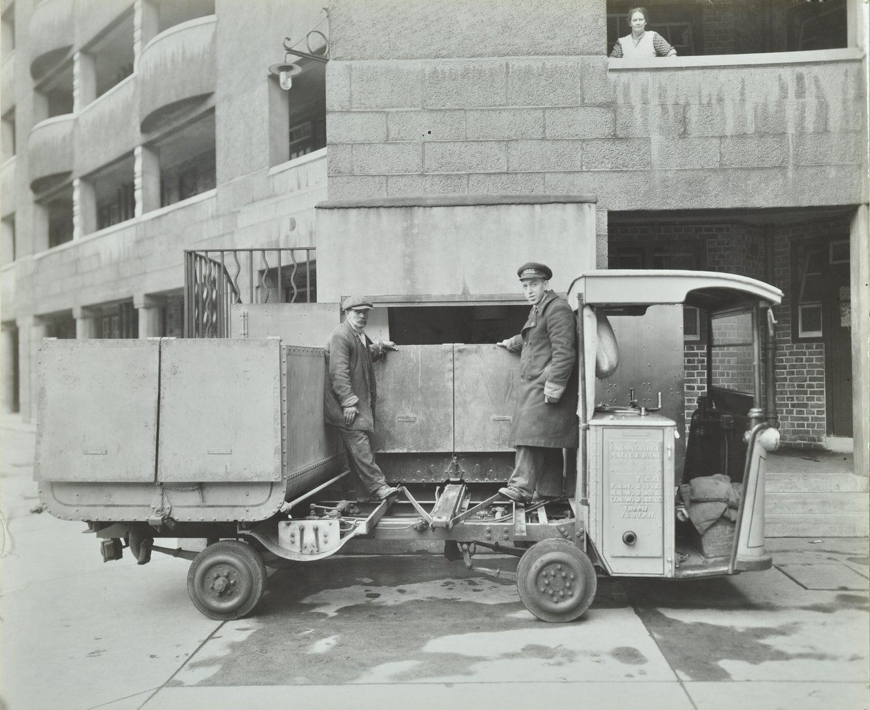 Ossulston Estate: dustmen empty container at the bottom of the rubbish chute by English Photographer