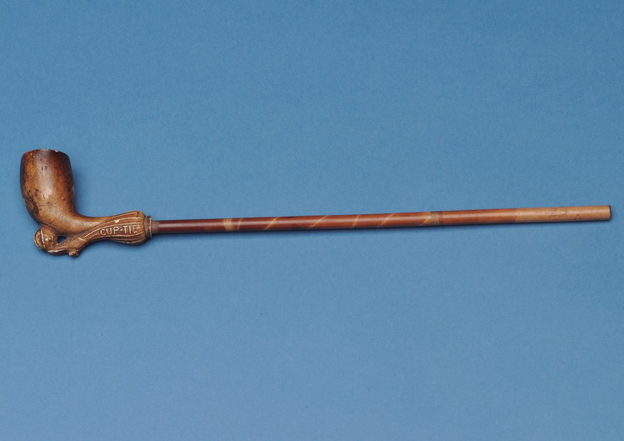 Cup tie pipe with bamboo stem and carved boot kicking a ball underneath (clay) by English School