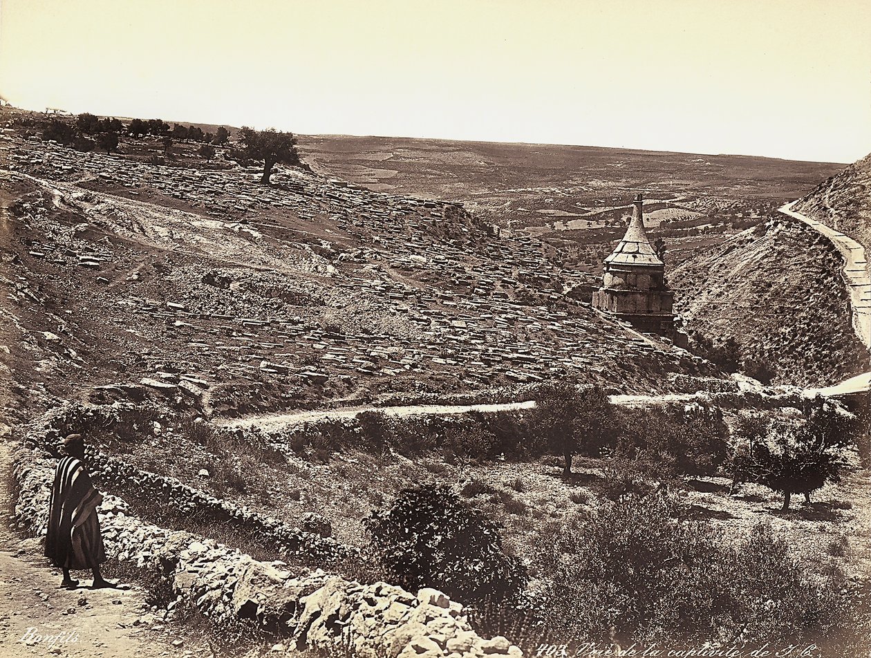 Panoramic view of the Valley of Cedron or Josafat, with the Tomb of Absalom, on the outskirts of Jerusalem. A man is looking at the view from the street by Félix Bonfils