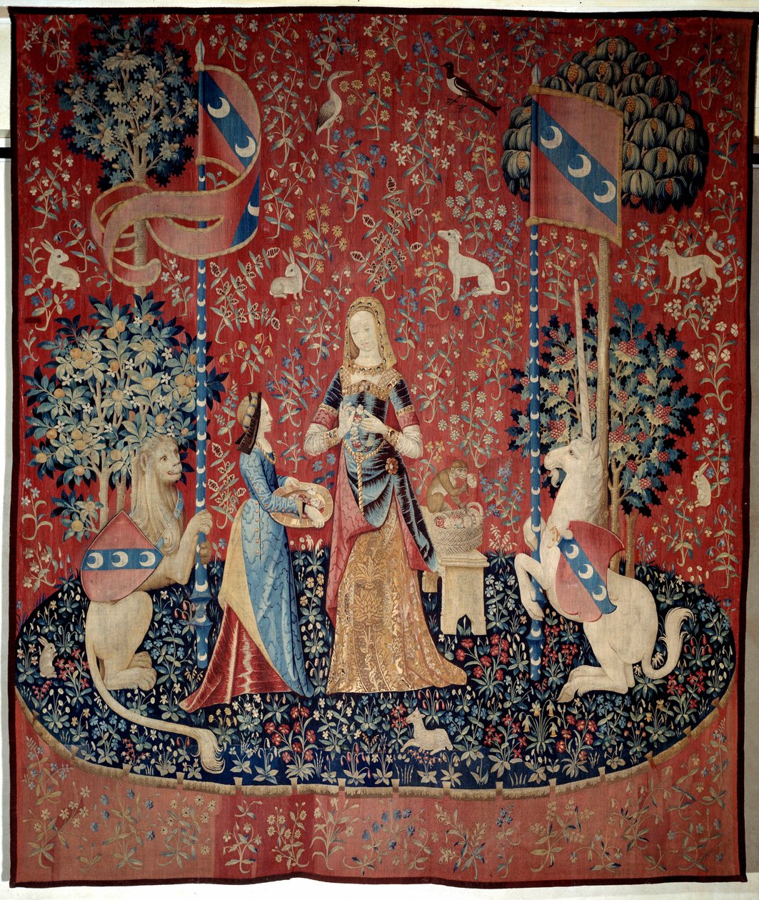 Curtain of the Lady to the Unicorn: allegory of smell. A young woman holding a crown of carnations, surrounded by a lion, a unicorn, a monkey, rabbits by French School