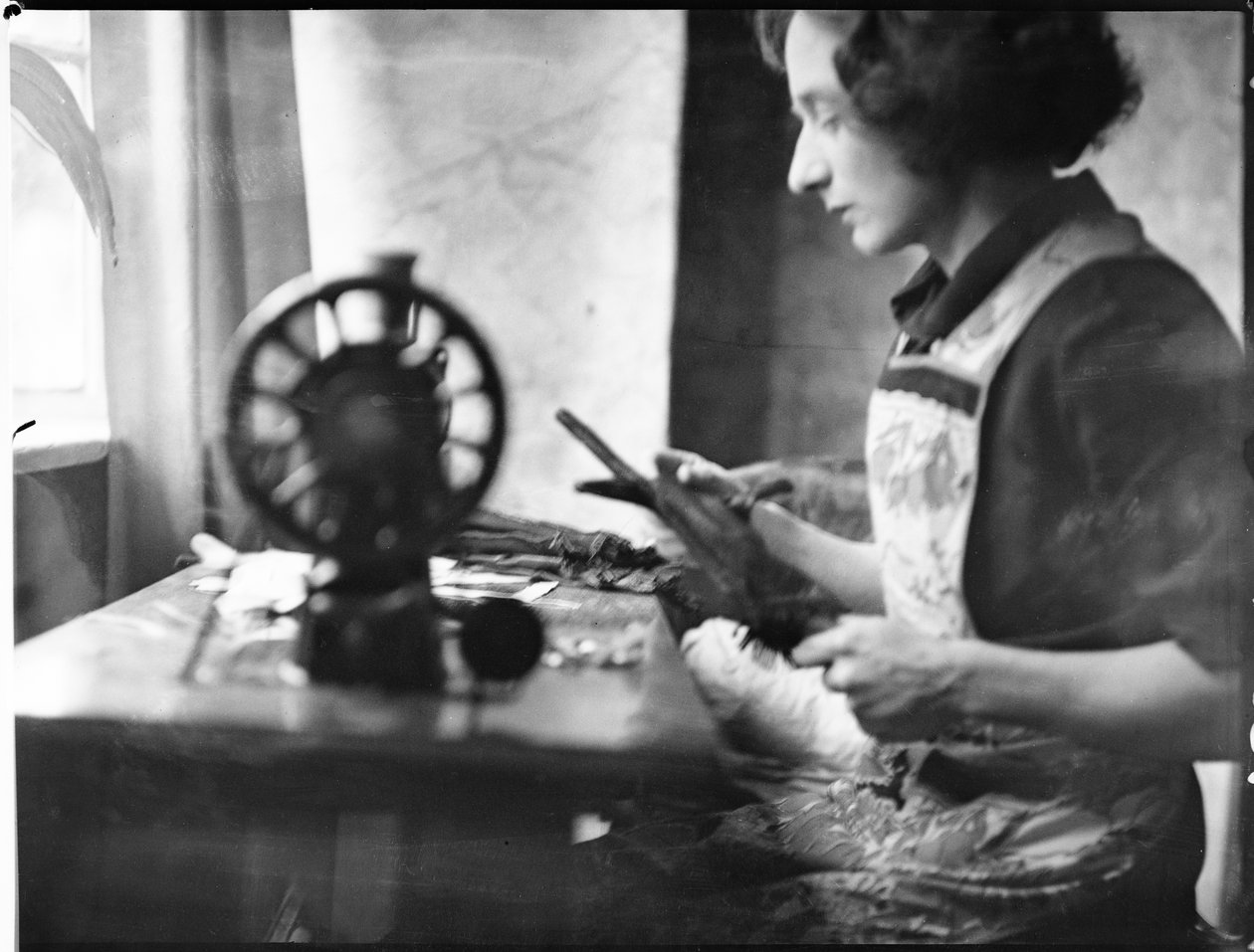A glover working at a sewing machine by George R. Long