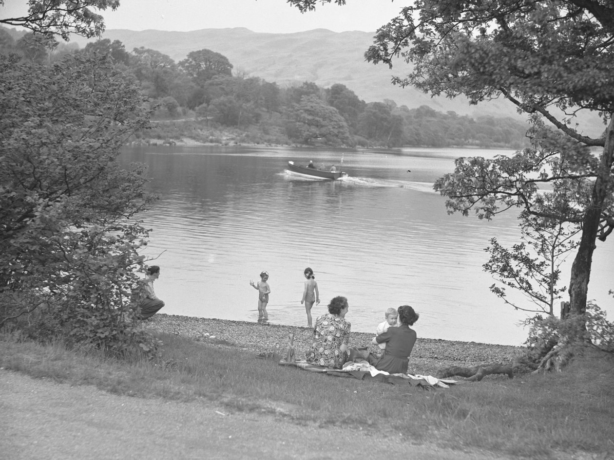 A family enjoying themselves next to a lake, boat on lake, hills in background by Joseph Hardman