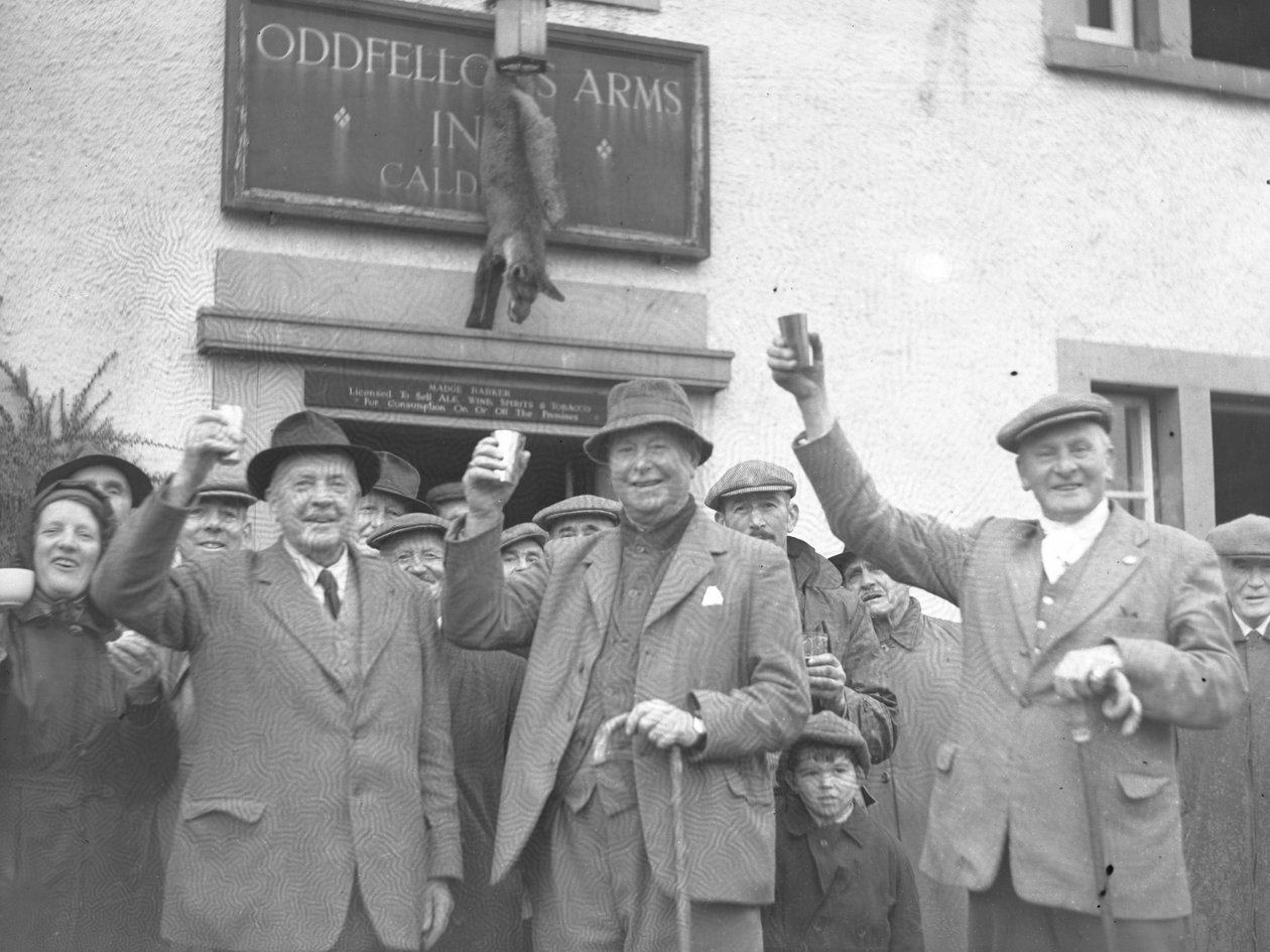 A group of men, women and children raising glasses in celebration standing outside Oddfellows Inn by Joseph Hardman