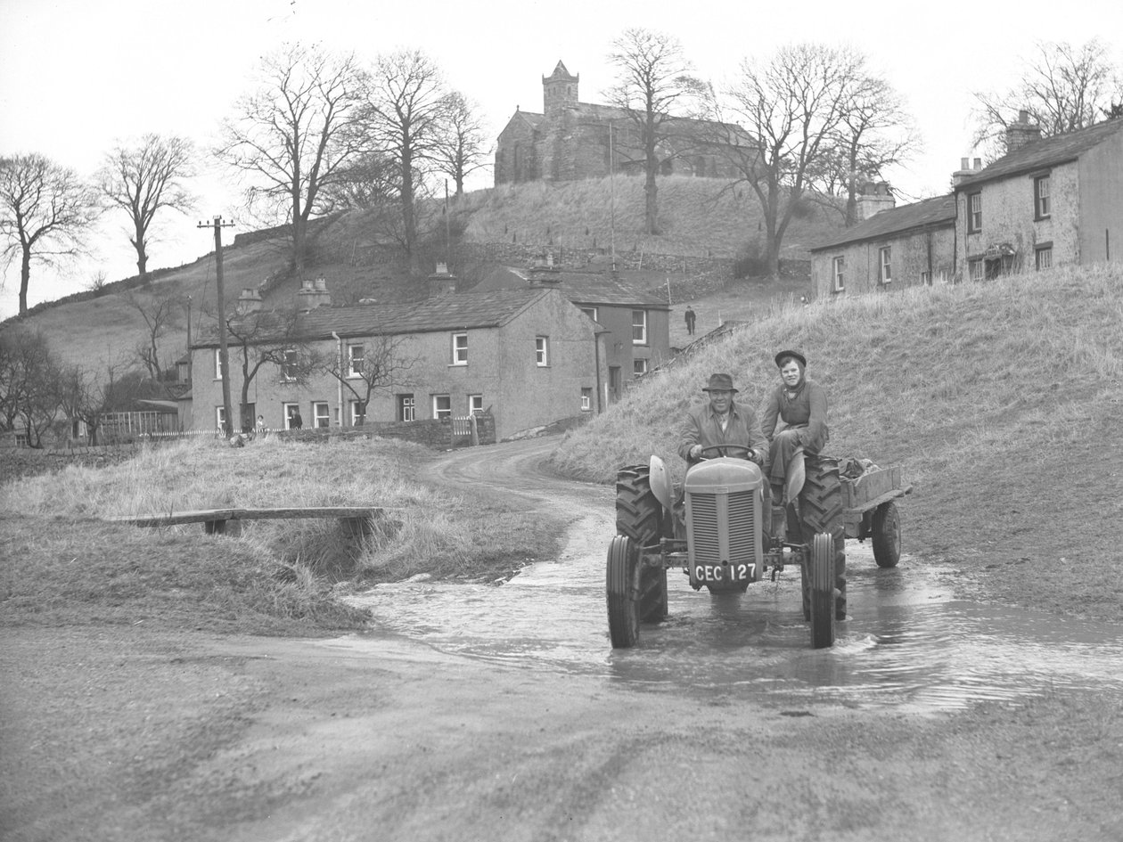 Man and woman driving tractor coming down road through ford at Crosby Garret by Joseph Hardman
