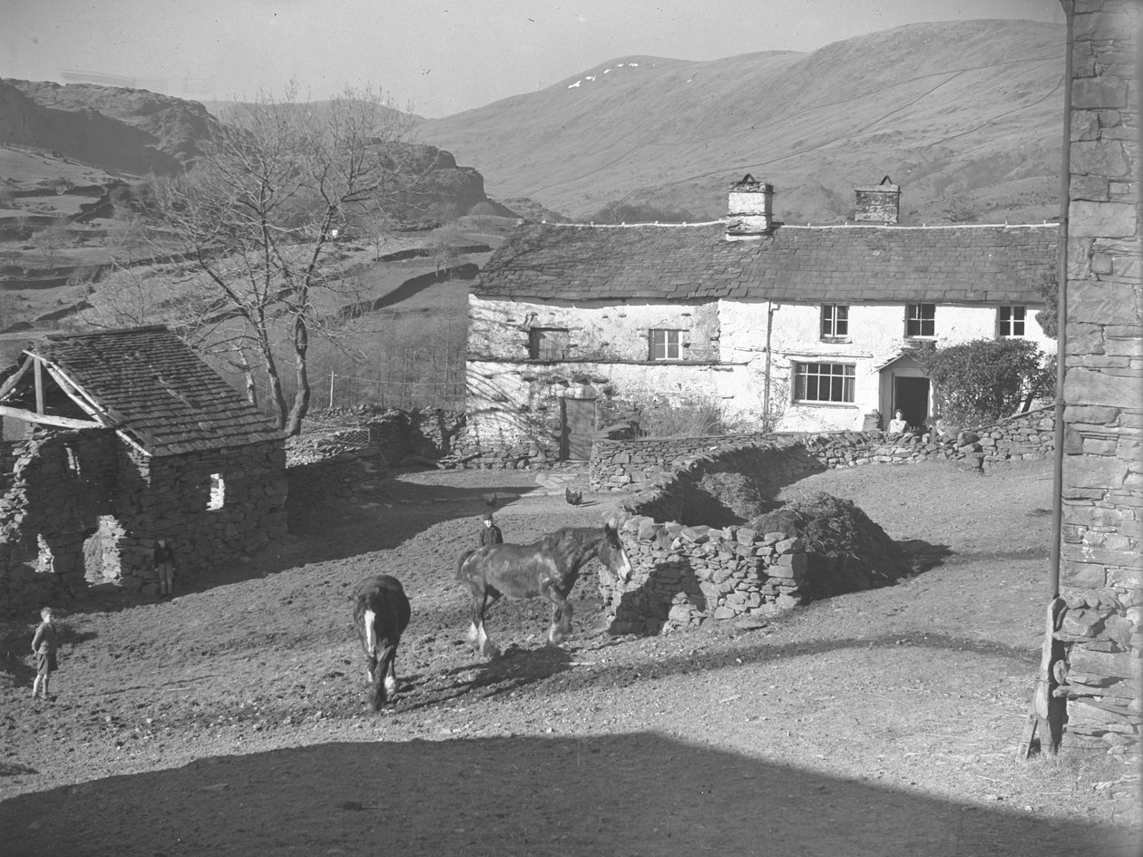 Three young boys watching horses in farmyard at Kentmere with farmhouse and hills behind by Joseph Hardman