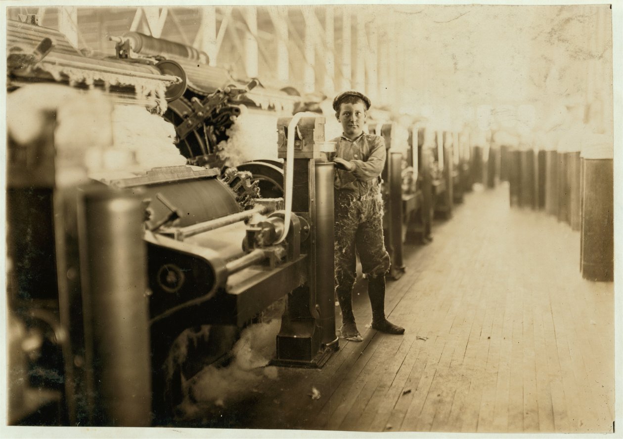 Boy sweeper by carding machines at Lincoln Cotton Mills, Evansville, Indiana in stockinged feet on a slippery floor, 1908 by Lewis Wickes Hine