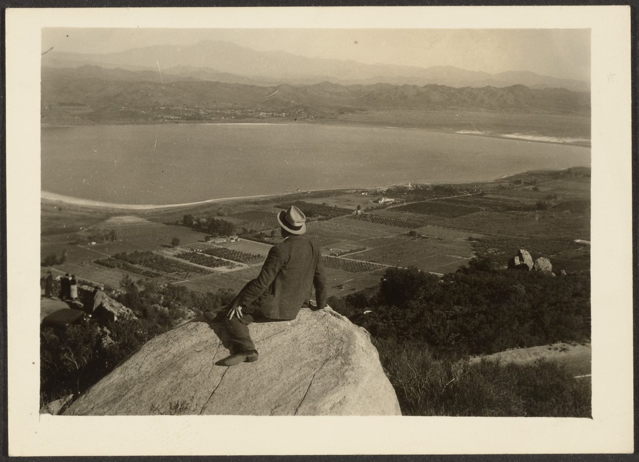 Man on Rock Promontory Overlooking Farmland by Louis Fleckenstein