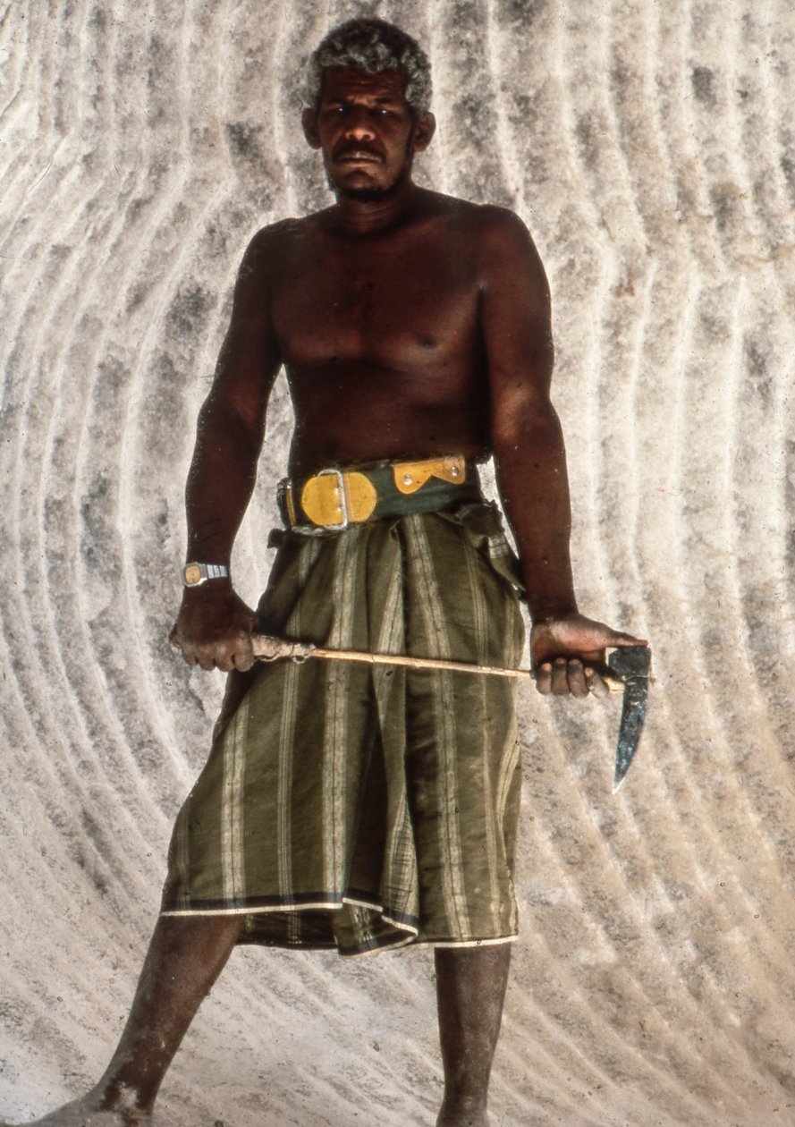 Yemenite man holding a salt pick in old salt mine in ancient city of Shabwah by Lynn Abercrombie