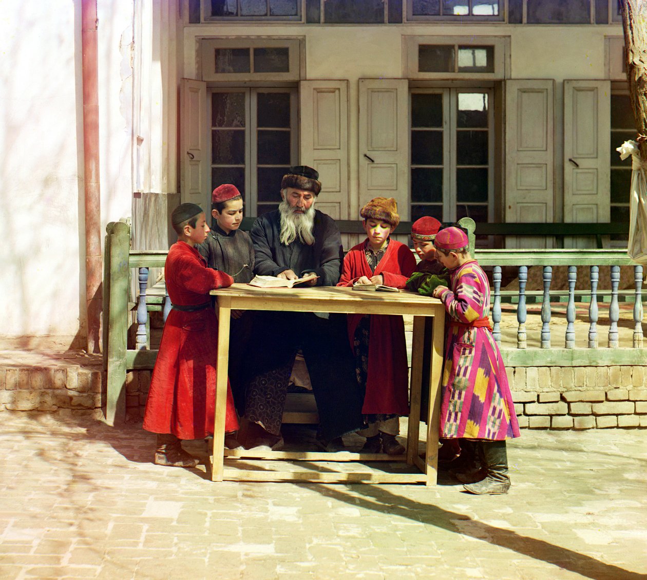 A Group of Jewish Children with a Teacher on a Table in Front of a House, Samarkand by Sergey Prokudin Gorsky