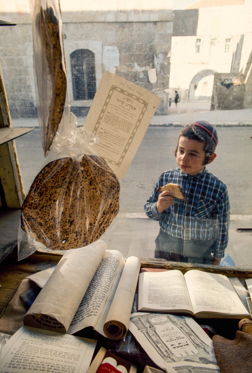 Conservative Jewish boy eating cake peers into a religious bookstore by Ted Spiegel