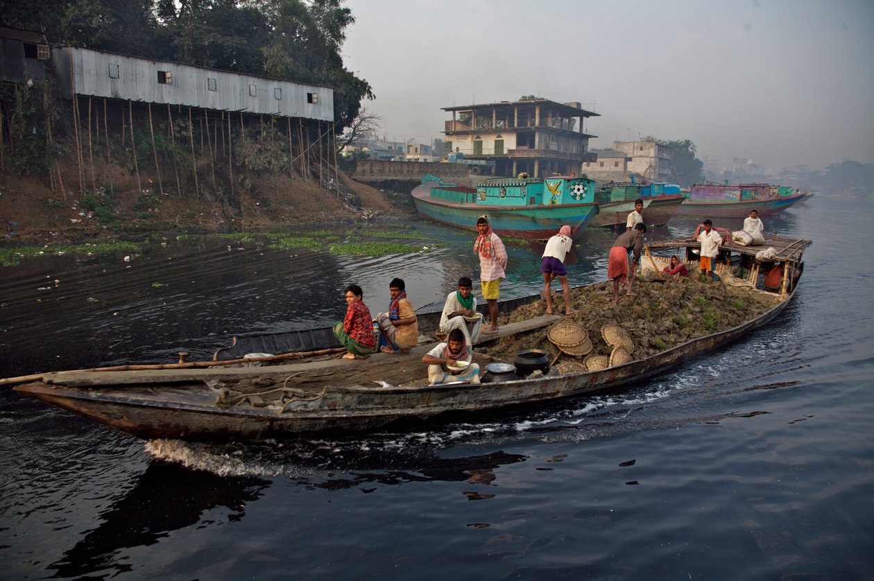 A boat carrying soil, used for filling up low land, through the Shitalakhya River, near the Tongi bridge, on the outskirts of Dhaka city. Bangladesh. February 19, 2007. by Unbekannt Unbekannt