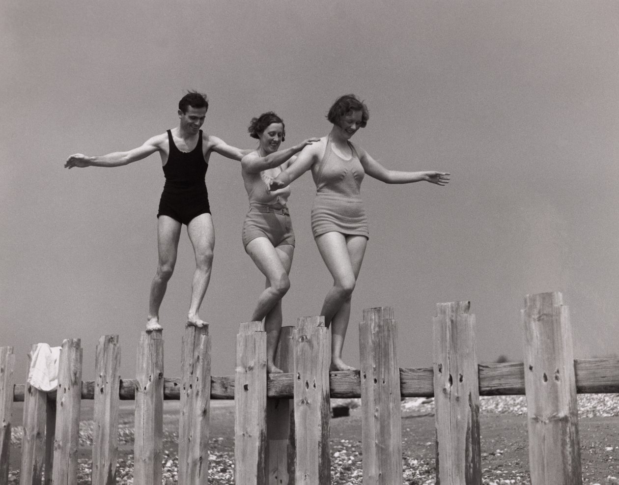 Two women and a man walking along a groyne, c 1930s by Unbekannt