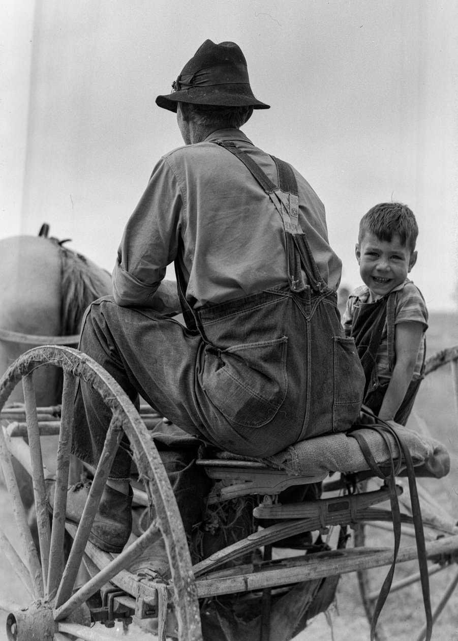 Farmer and smiling boy ride on the seat of a horse-drawn buggy in West Virginia by Volkmar Wentzel