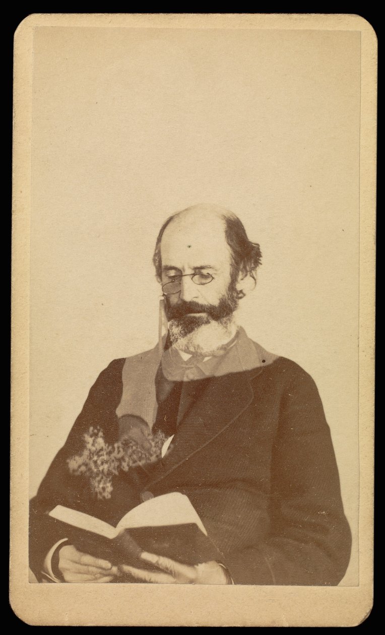 Unidentified balding, bearded man reading while seated by William H. Mumler