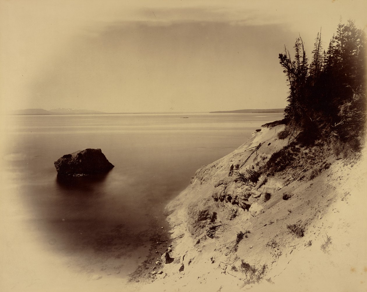Unidentified Western Landscape with Lake and Large Rock Off Shore by William Henry Jackson