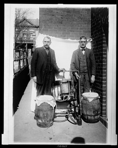 Two men posing with a whiskey still