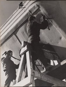 Two Men Work on the Underside of a Boat