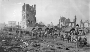 An unidentified Australian Machine Gun section with packed horses passing the ruins of the Cloth Hall. Note several motor lorries parked in the background, 19 October 1917 by Australian Photographer
