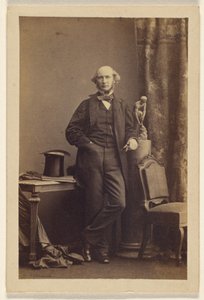 Unidentified man standing, top hat on table