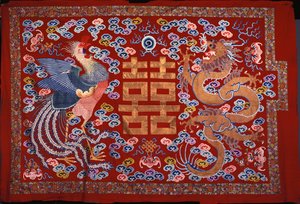 A Chinese Hanging of Red Wool with a Central Character in Gilt Thread Flanked by a Phoenix and a Dragon by Chinese School