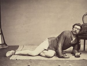 Man in Chainmail Tunic Posing as a Dying Soldier