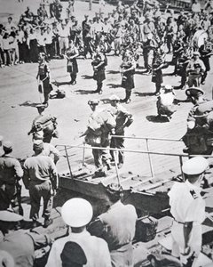 Kilted pipers play ashore from the 1st Battalion Argyll and Sutherland Highlanders from HMS Ceylon at Pusan, 29th August 1950 by English Photographer