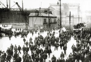 Knocking-off time at the Harland and Wolff shipyard, Belfast, Ireland with the Titanic under construction in the background, 1910-11 by English Photographer