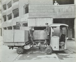 Ossulston Estate: dustmen empty container at the bottom of the rubbish chute by English Photographer