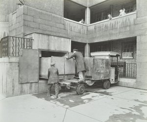 Ossulston Estate: dustmen empty container at the bottom of the rubbish chute by English Photographer