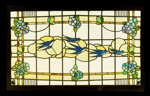 Arts and Crafts panel of a group of swallows before clouds in a border of stylised flowerheads