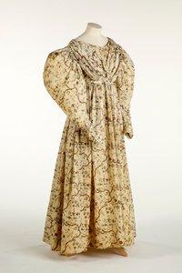 Dress printed with a flower and branch design on cream woven fabric with grid pattern in the weave, c.1830-35