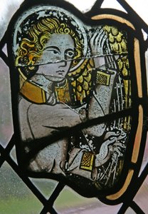 Window in the Cloisters depicting a musician angel with a harp by English School
