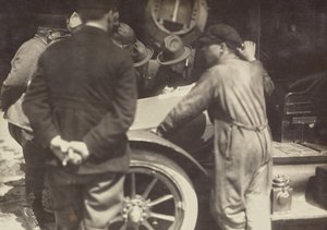 Men Grouped Around the Hood of a Car