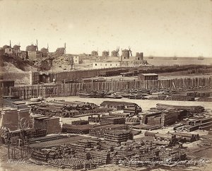 Yard for construction materials, windmills are in the background, in Alexandria, Egypt by Félix Bonfils