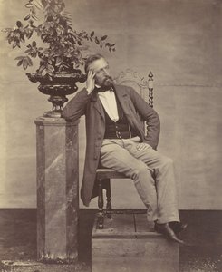 Mathias Höusermann seated with elbow on pedestal holding a vase of flowers by Franz Antoine