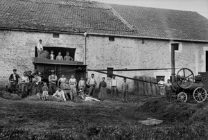 Agricultural workers and the press tied hay boots on a farm near Bourmont in Haute-Marne, around 1890. Photography. Ducos Collection.