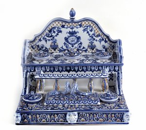 French calligraphy: Writing in porcelain of Gien, with a total length of 40 centimetres, this piece is very representative of the 18th century. There are 5 inkbeds on two stages, as well as a rectangular plumboard. Paris, the pen museum.