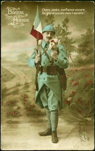 Greeting postcard for the year 1916. A soldier carrying the French flag with a gun and humbling the fragrance of a bouquet of flowers in a country landscape. Colour postcard for the wishes of the year 1916